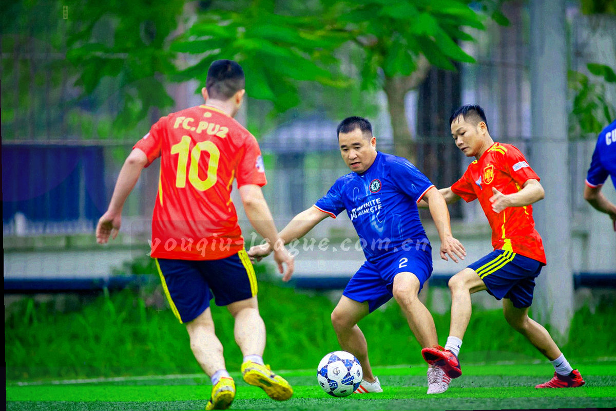夜间办公区的多屏桌面与球场直播画面，只见背影与手部